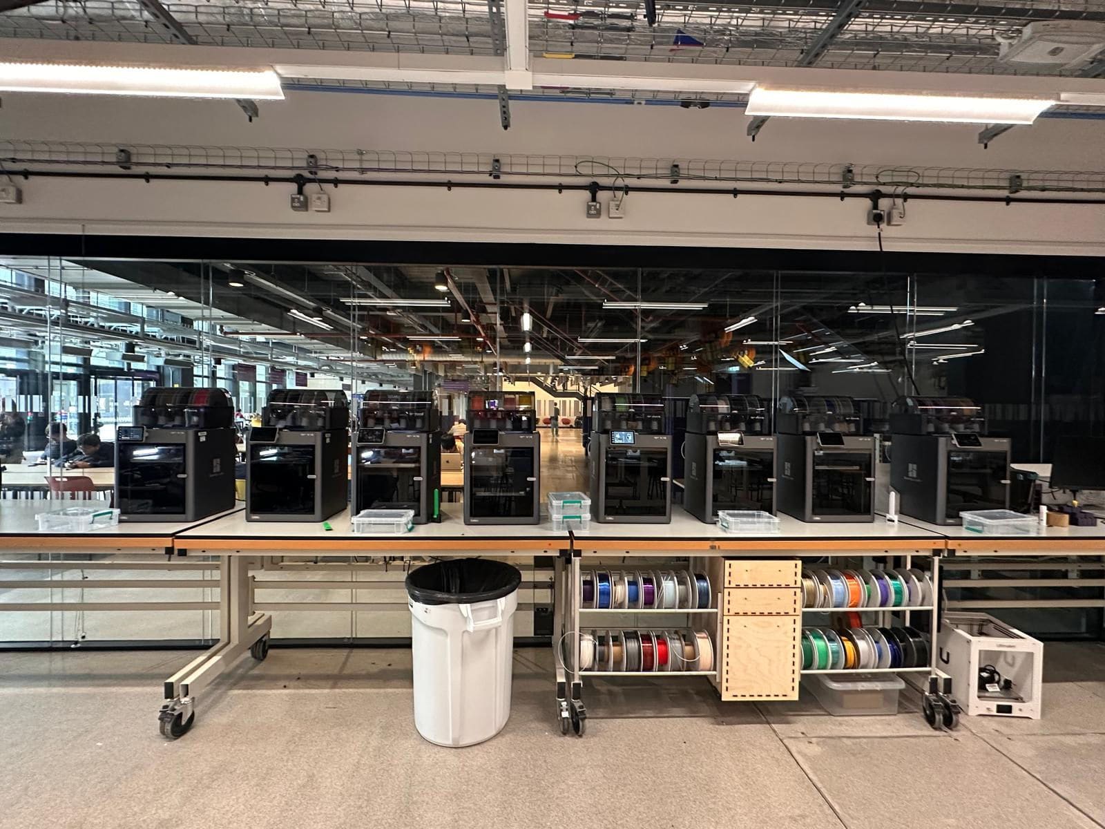 A row of 3D printers and filament spools inside the Makerspace.