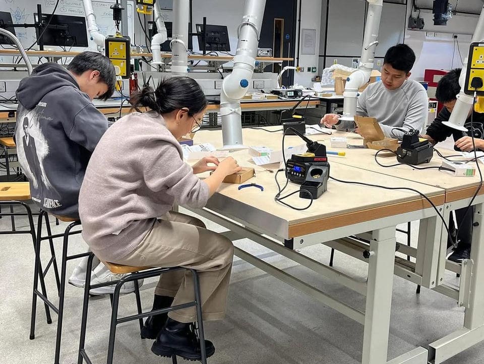 Students using soldering stations and bench space in the Makerspace.